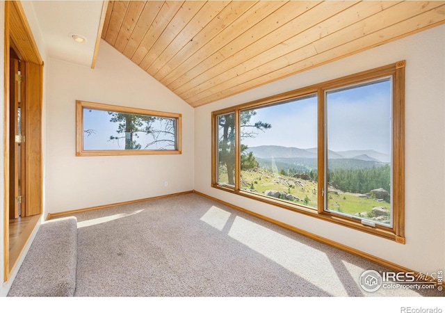 carpeted spare room with a mountain view, wooden ceiling, and vaulted ceiling