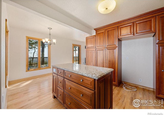 kitchen with light hardwood / wood-style flooring, light stone countertops, and plenty of natural light