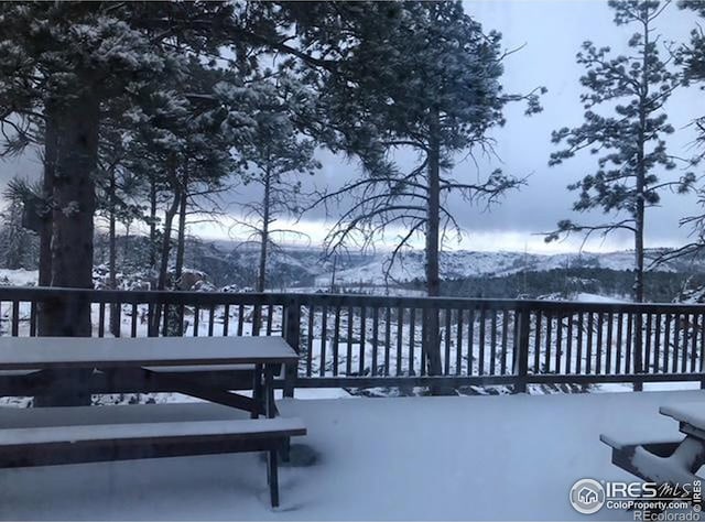 snow covered deck featuring a mountain view