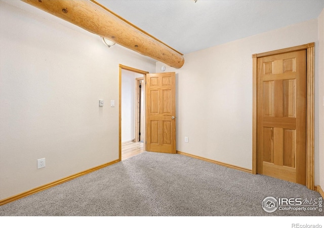 spare room with carpet floors and beamed ceiling