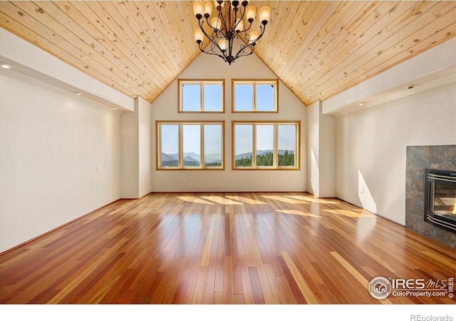 unfurnished living room with a fireplace, wood-type flooring, wood ceiling, and an inviting chandelier