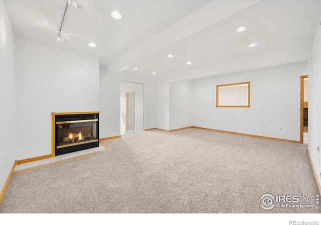 unfurnished living room with a multi sided fireplace and light colored carpet