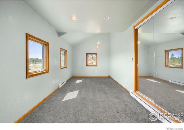 carpeted spare room with baseboard heating and lofted ceiling