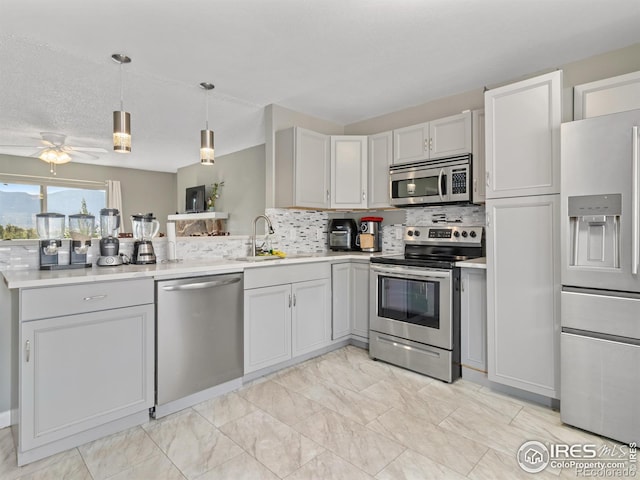 kitchen with appliances with stainless steel finishes, backsplash, decorative light fixtures, light tile patterned floors, and ceiling fan