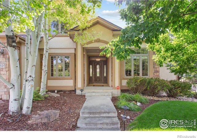 property entrance with stucco siding