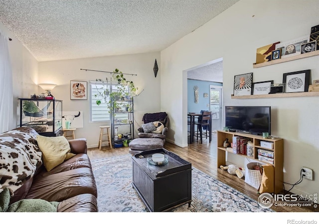 living room featuring plenty of natural light, vaulted ceiling, a textured ceiling, and hardwood / wood-style floors