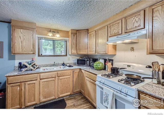 kitchen featuring sink, white range with gas stovetop, a textured ceiling, light brown cabinets, and hardwood / wood-style flooring