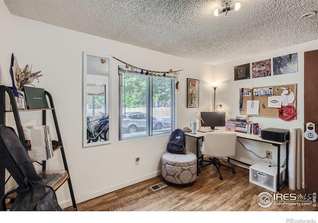 home office featuring a textured ceiling and hardwood / wood-style floors