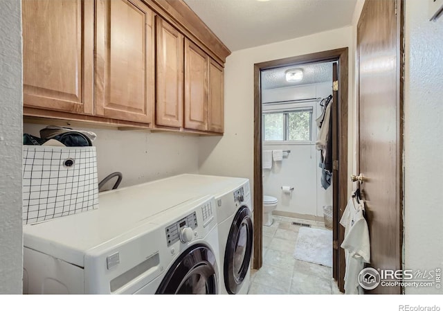 laundry area with cabinets, washer and clothes dryer, and a textured ceiling