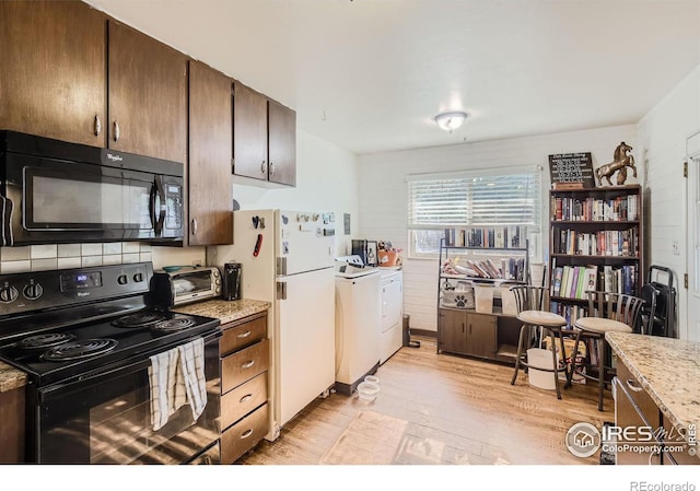 1308 Castlerock Dr, Fort Collins, CO 80521 - kitchen with light hardwood / wood-style flooring, light stone counters, black appliances, washer / clothes dryer, and dark brown cabinetry