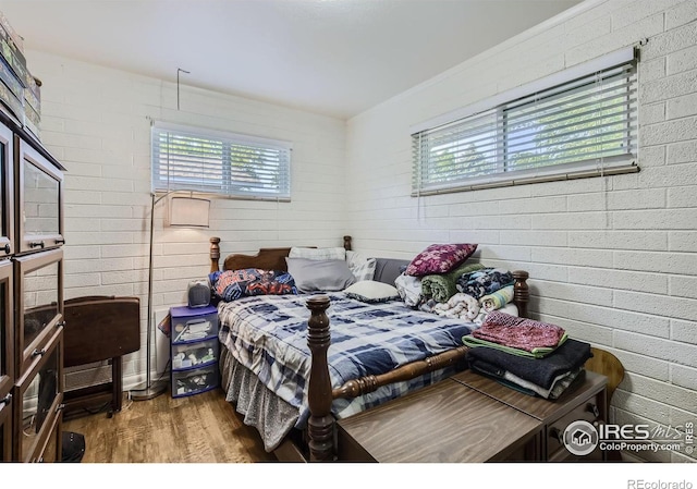 1308 Castlerock Dr, Fort Collins, CO 80521 - bedroom featuring hardwood / wood-style flooring and brick wall