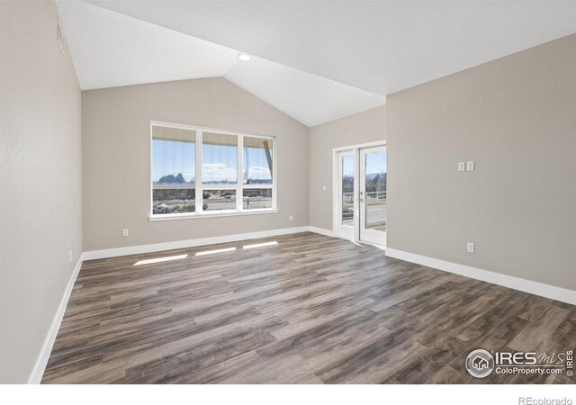 unfurnished room with dark wood-type flooring and lofted ceiling