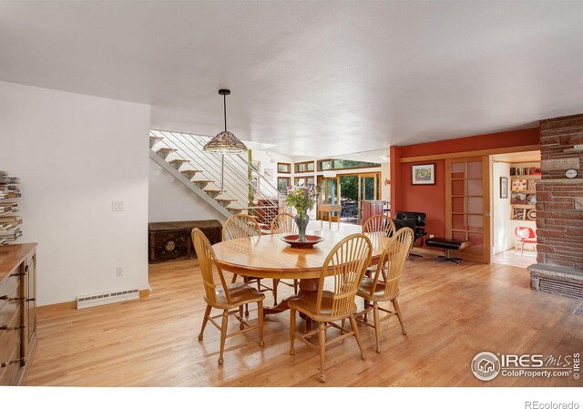 dining area featuring light hardwood / wood-style flooring and brick wall