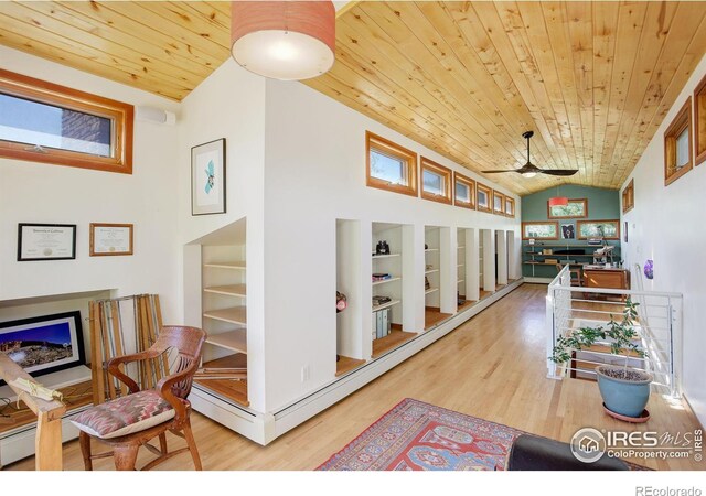 hall featuring a healthy amount of sunlight, vaulted ceiling, light hardwood / wood-style flooring, and wooden ceiling