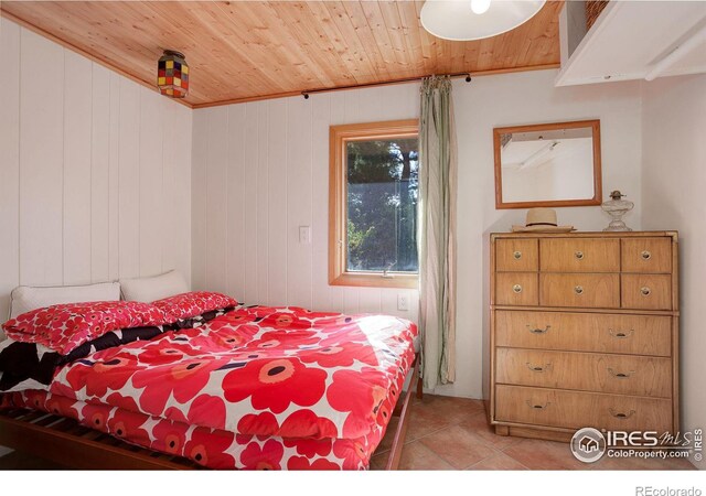 bedroom with wooden ceiling and light tile patterned floors