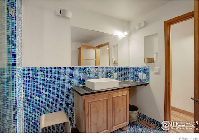 bathroom with vanity, tasteful backsplash, and tile walls