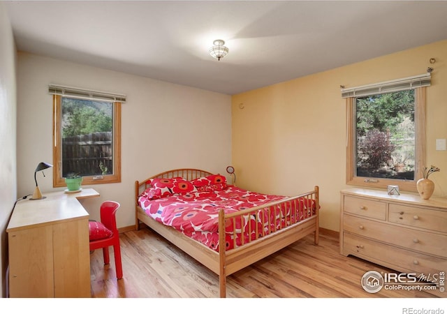 bedroom with multiple windows and light wood-type flooring