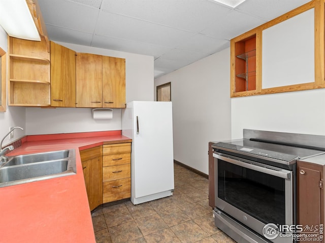 kitchen with stainless steel electric range oven, open shelves, a sink, and freestanding refrigerator