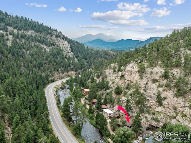 birds eye view of property with a mountain view and a forest view