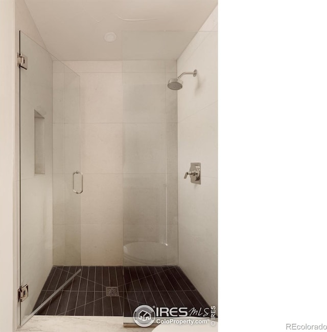 bathroom featuring a shower with door