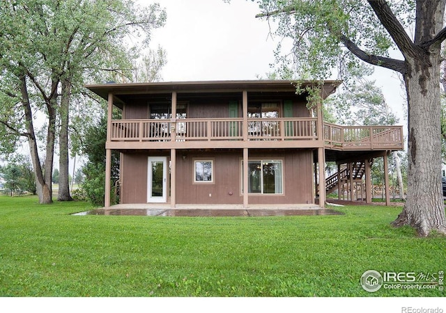 back of property with a wooden deck and a yard