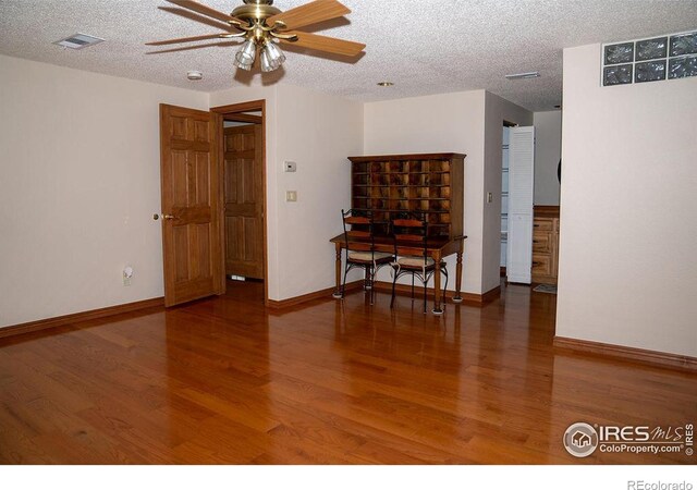 unfurnished room featuring ceiling fan, wood-type flooring, and a textured ceiling