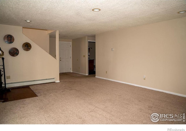 spare room featuring a baseboard radiator, carpet flooring, and a textured ceiling