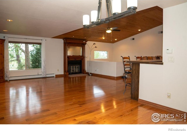 unfurnished living room with a baseboard radiator, a healthy amount of sunlight, and light wood-type flooring