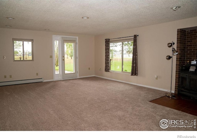 unfurnished living room featuring dark colored carpet, a wood stove, a textured ceiling, and a baseboard radiator