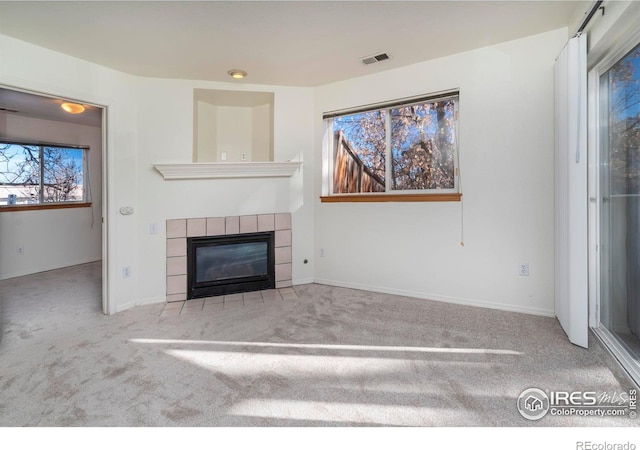 unfurnished living room featuring light colored carpet and a fireplace