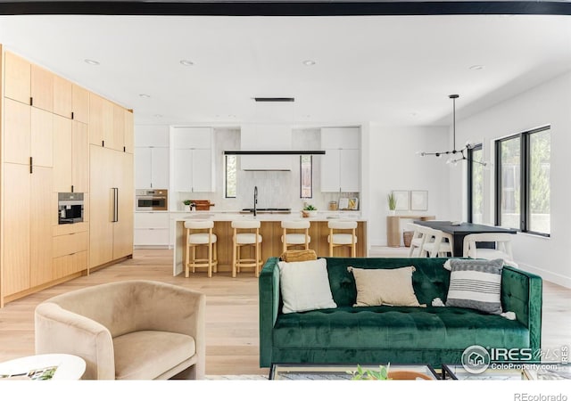 living room featuring sink and light wood-type flooring