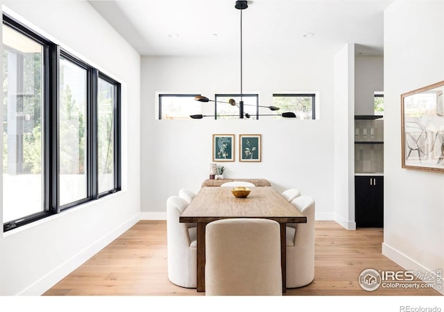 unfurnished dining area featuring a notable chandelier and light hardwood / wood-style flooring