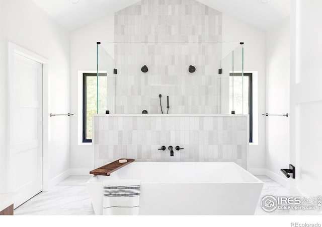 bathroom featuring vaulted ceiling and independent shower and bath