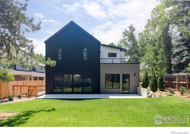 rear view of house with a patio and a lawn