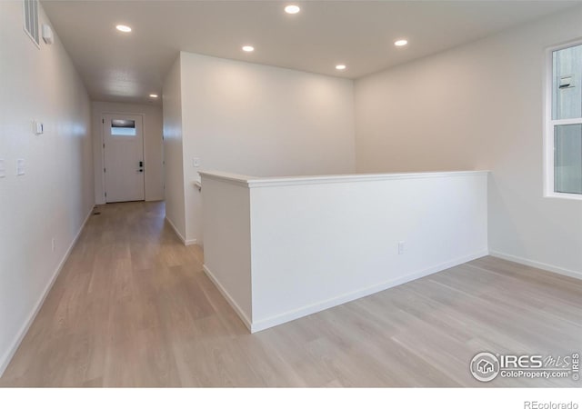 hallway with light hardwood / wood-style floors