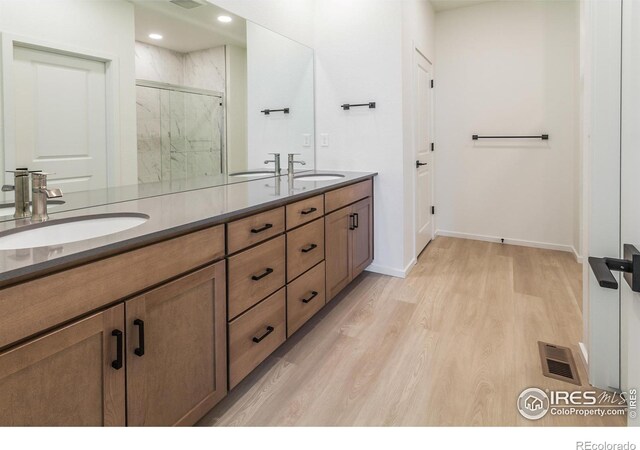 bathroom featuring vanity, hardwood / wood-style floors, and a shower with shower door