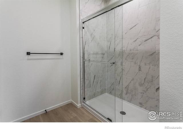 bathroom featuring an enclosed shower and wood-type flooring