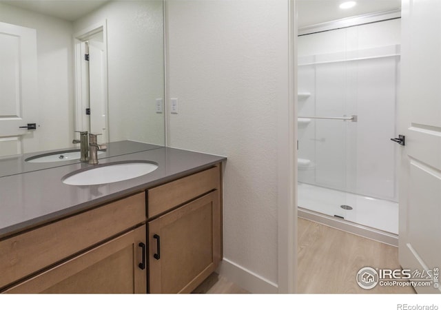 bathroom featuring vanity, hardwood / wood-style floors, and an enclosed shower