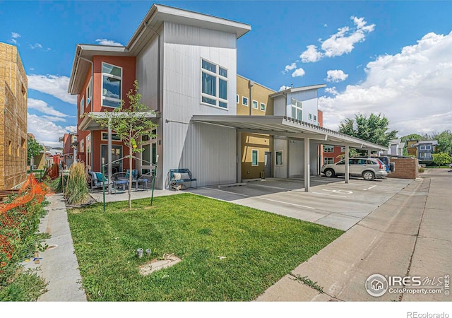 exterior space featuring covered parking and a yard