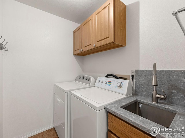 washroom featuring cabinets, sink, and washer and clothes dryer