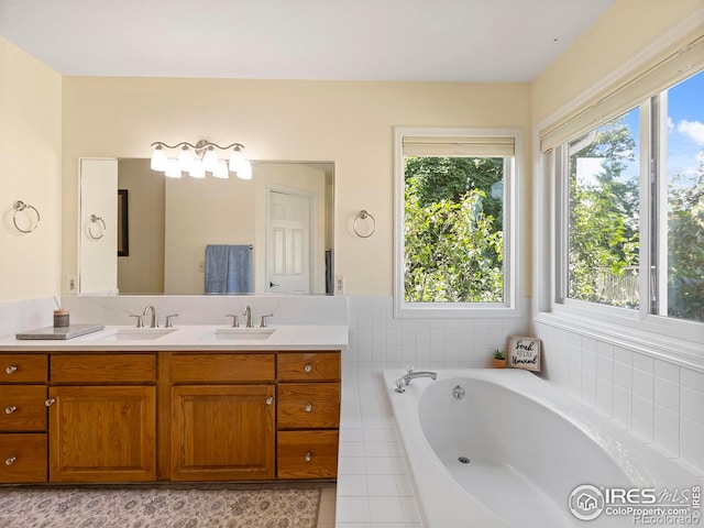 bathroom featuring vanity, tiled tub, and tile patterned flooring