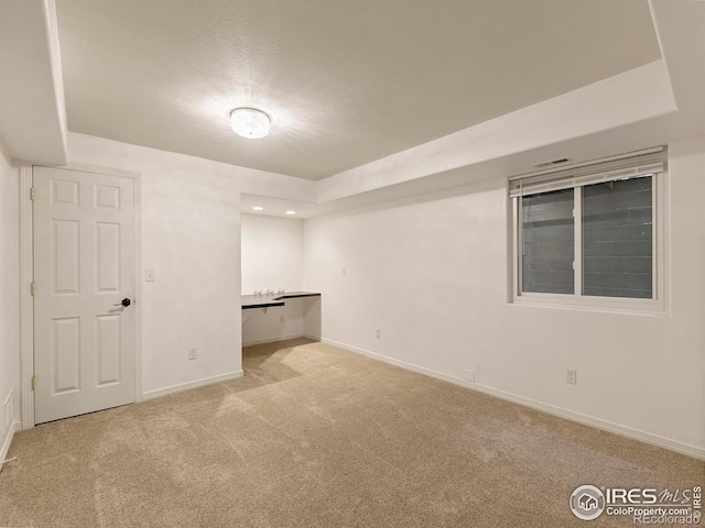 carpeted spare room with a textured ceiling