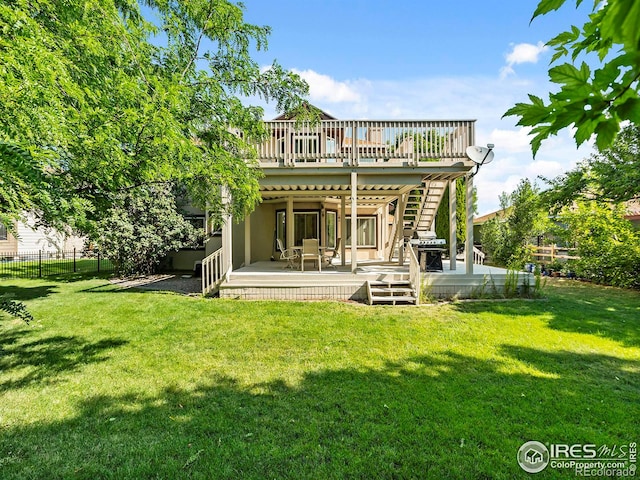 rear view of house with a yard and a deck