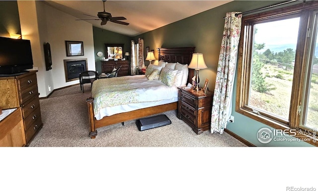 bedroom featuring ceiling fan, lofted ceiling, multiple windows, and carpet