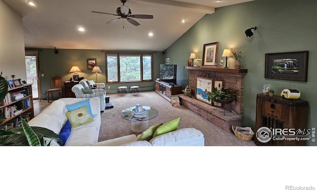 carpeted living room featuring ceiling fan, lofted ceiling with beams, and a stone fireplace