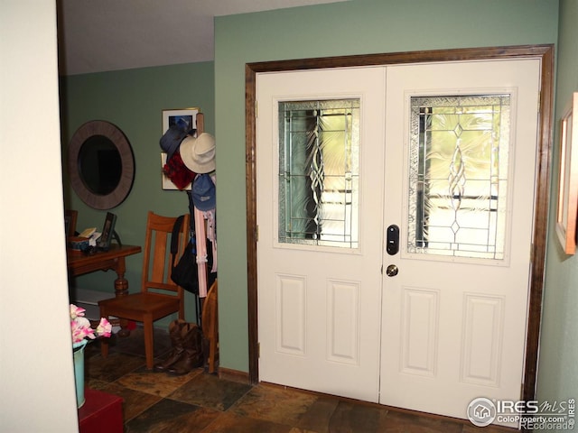 doorway with dark tile patterned flooring and a wealth of natural light