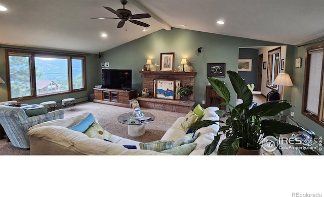 carpeted living room featuring ceiling fan, lofted ceiling with beams, and a brick fireplace