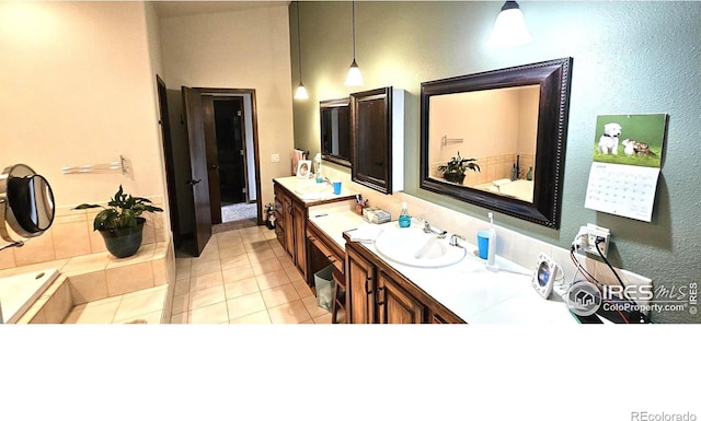 bathroom featuring double sink vanity, tile patterned floors, and tiled bath