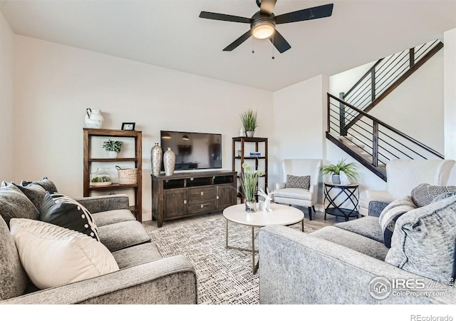 living area featuring stairs and ceiling fan