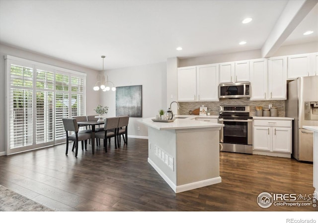 kitchen with sink, decorative light fixtures, white cabinetry, decorative backsplash, and appliances with stainless steel finishes